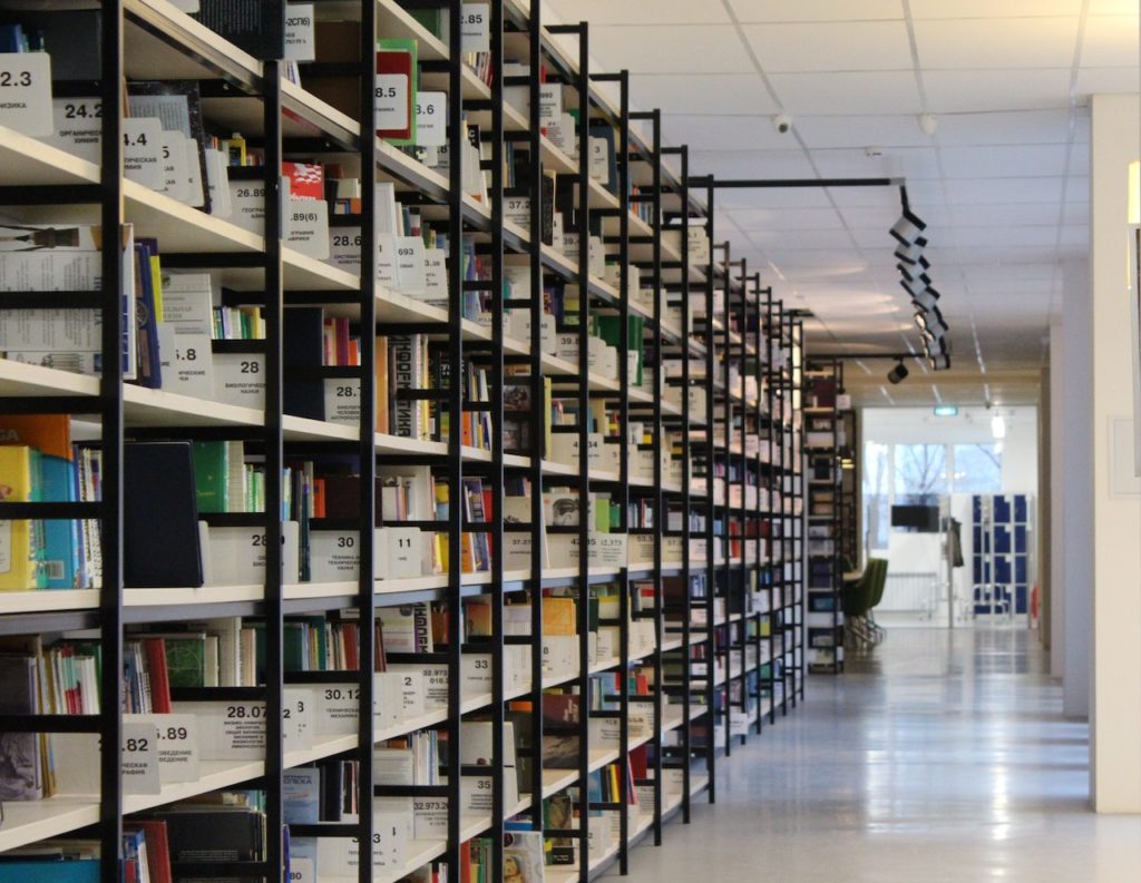 A neat shelf of books on the left side of a corridor