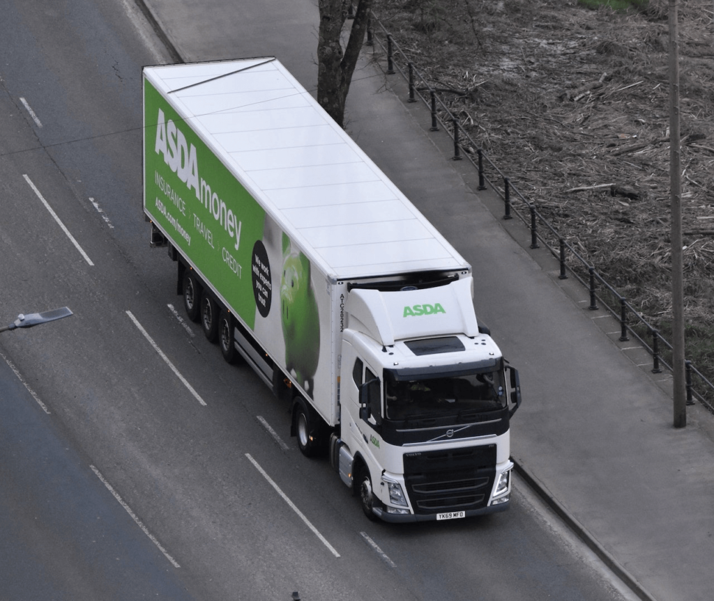 White delivery truck traveling down a highway